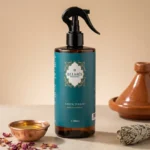 Flacon spray parfum d'ambiance Santal d'Atlas Belmés Profissional 500ml – bol cuivré huile pétales de rose sauge blanche et tajine en terre cuite en arrière-plan
