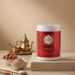 Pot masque argile ghassoul Belmés Profissional – poudre rhassoul noix d'argan théière dorée marocaine et pinceau application en arrière-plan