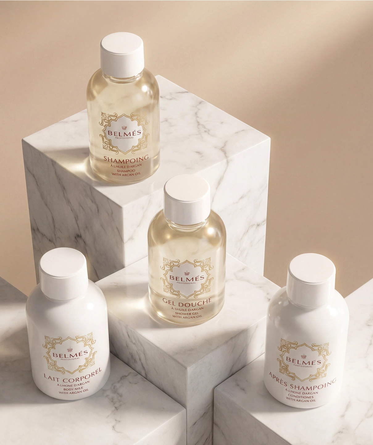 Gamme amenities hôtel Belmés Profissional – shampoing gel douche lait corporel et après-shampoing à l'huile d'argan sur socles en marbre blanc