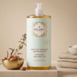 Flacon huile de massage amincissante Belmés Profissional – noix d'argan dans bol doré et plantes aromatiques en arrière-plan zones rebelles et cellulite